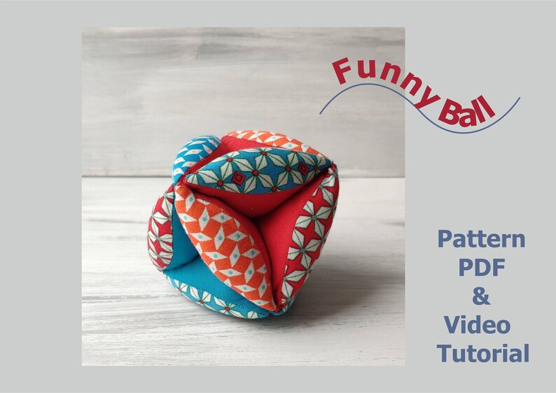 May include: A colorful fabric ball with a geometric pattern. The ball is made of six pieces of fabric sewn together. The fabric is red, orange, blue, and white. The ball is on a white wooden surface. The text "Funny Ball" is written in red above the ball. The text "Pattern PDF & Video Tutorial" is written in black below the ball.