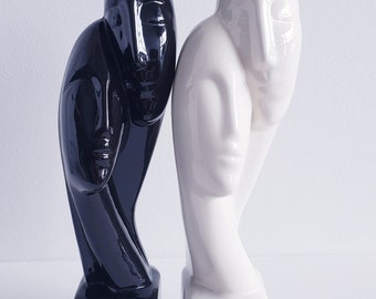 Ceramic statue of man and woman in black or white, known as 'Devotion'