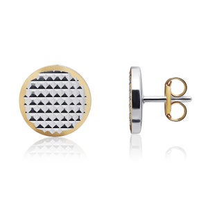 May include: A pair of round stud earrings with a textured silver center and a gold rim. The earrings have a post and butterfly back.