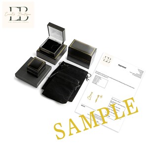 May include: A black velvet jewelry pouch, a black jewelry box with a gold trim, and a black jewelry box with a gold trim. A white appraisal document with the text "Appraisal" and a gold heart-shaped earring design. The document has the text "E.B. Fine Jewellery London" at the top.