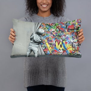 May include: A decorative throw pillow with a colorful graffiti design. A child is shown pulling back a curtain to reveal the graffiti. The graffiti includes the word "LOVE" in large letters.