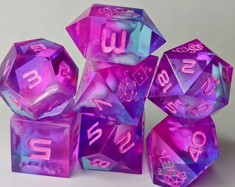 May include: A set of six iridescent dice with pink and purple swirls. The dice are numbered 1 through 6 and have a white background with pink numbers.