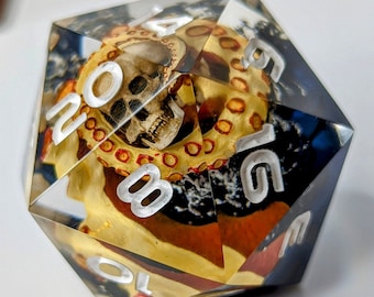 May include: A clear, multi-sided dice with a skull and tentacles design. The dice has white numbers on each side, including the numbers 10, 8, 6, 4, 2, and 1.