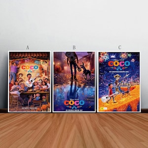 Peut inclure: Trois affiches encadrées du film Disney Pixar "Coco" sont présentées. Les affiches présentent des images colorées du film d'animation, notamment des personnages, des instruments de musique et des décorations festives. Les affiches sont exposées sur un sol en bois.