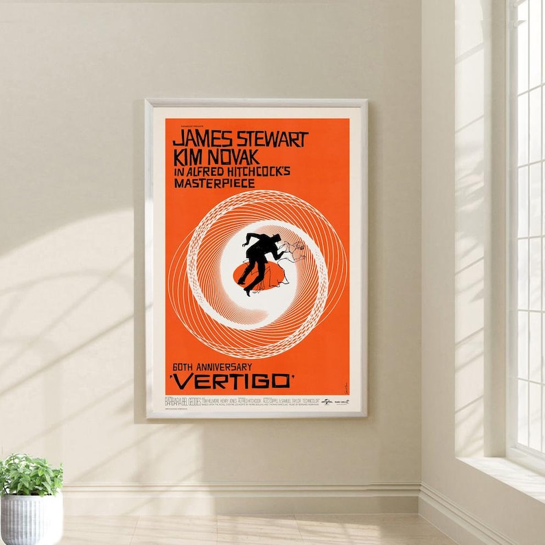 May include: A vintage movie poster for the film "Vertigo" starring James Stewart and Kim Novak. The poster features a swirling spiral design in orange and white with a silhouette of a man running in the center. The text "60th Anniversary" is at the bottom of the poster.