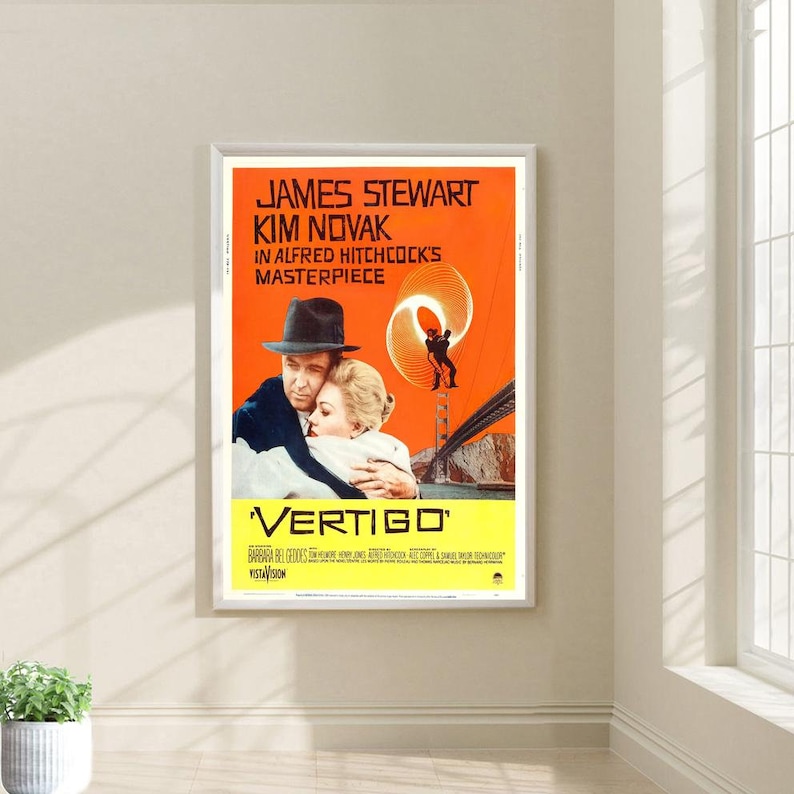 May include: A vintage movie poster for the film "Vertigo" starring James Stewart and Kim Novak. The poster features a red background with a swirling pattern and a silhouette of a man falling from a building. The text "Vertigo" is in a yellow box at the bottom of the poster.