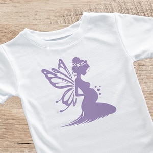 Könnte beinhalten: Ein weißes T-Shirt mit einer lila Silhouette einer schwangeren Fee mit Flügeln und einer Blumenkrone.