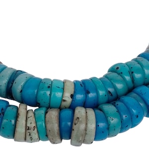 May include: A strand of blue and turquoise beads, made of natural materials, with a speckled finish. The beads are round and have a slightly irregular shape.