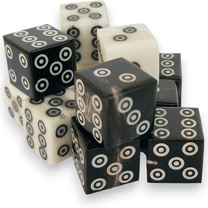 May include: A set of ten black and white dice with a circle pattern. The dice are made of bone and have a natural, polished finish.
