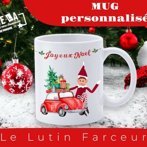 Peut inclure: Mug en céramique blanche avec un lutin de Noël conduisant une Volkswagen Beetle rouge avec un sapin de Noël sur le toit. Le mug porte l'inscription "Joyeux Noël".