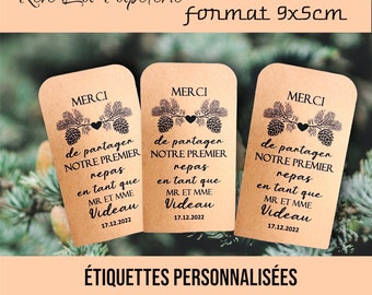 Può includere: Tre etichette regalo in carta marrone con il testo "MERCI" e un design a pigna. Il testo recita "de partager notre premier repas en tant que MR. ET MME Videau 17.12.2022". Le etichette misurano 9 cm per 5 cm.