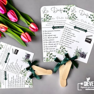Peut inclure: Deux éventails verts et blancs avec un ruban vert. Les éventails ont une liste de défis photo écrits en français. Le texte sur les éventails indique "Le Défi des Photos de Marie" et "123 Photos".