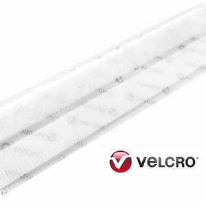 May include: White VELCRO® brand hook and loop fastener strips. The image shows two strips of white hook and loop material, one with a fuzzy texture and the other with a looped texture. The VELCRO® logo is in the bottom right corner.