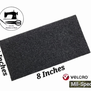 May include: A 4 inch by 8 inch black piece of hook and loop fastener, also known as Velcro. The product is labeled "Mil-Spec" and is made by Velcro.