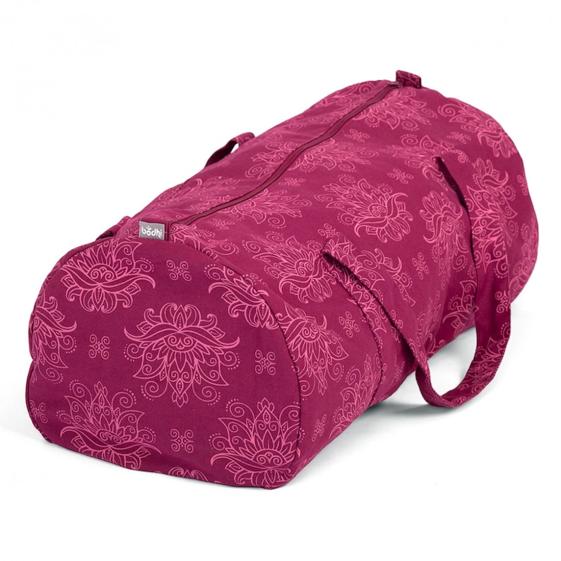Puede incluir: Una bolsa de yoga color burdeos con un estampado floral rosa y la palabra "Bodhi" impresa en el lateral.
