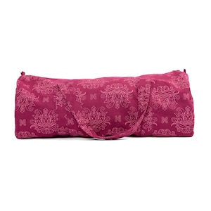 Puede incluir: Una bolsa de yoga rosa con un estampado floral blanco. La bolsa tiene una cremallera y dos asas.