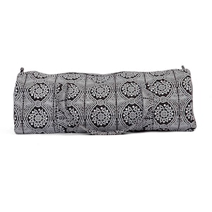 Puede incluir: Una bolsa de lona negra y blanca con un dise&ntilde;o circular. La bolsa tiene dos asas negras.