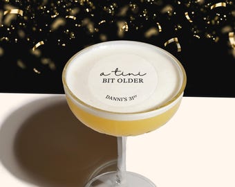 May include: A cocktail with a white foam top and a round sticker that says "a  tini bit older" and "Danni's 31st" in black text.