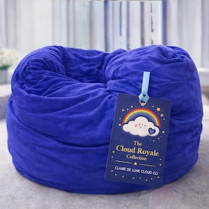 May include: A large, round, blue beanbag chair. A tag is attached with a rainbow, cloud, and star design, and the text "The Cloud Royale Collection" and "Claire de Lune Cloud Co."