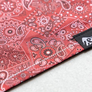 Può includere: Bandana rossa con motivo paisley e un'etichetta nera con la scritta " Hanks Lefant"