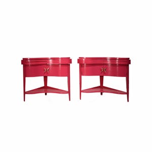 May include: Two matching hot pink nightstands. Each has a curved front with a small drawer and a starburst-shaped handle. The nightstands have a triangular shelf and legs. The nightstands are a bright, bold color.