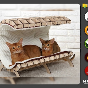 May include: A wooden cat bed with a white furry lining. Two brown tabby cats are resting inside the bed. The bed has a curved roof and is supported by four legs. The bed is made of laser-cut wood and is designed for cats to sleep and relax.