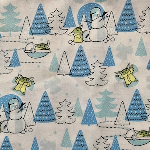 May include: A white fabric with a repeating pattern of blue and green Christmas trees, snowmen, and small green characters. The characters are wearing yellow robes and have large ears.