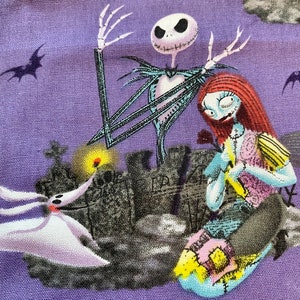 May include: A purple fabric with a printed image of Jack Skellington and Sally from the Nightmare Before Christmas. The image is set against a backdrop of a graveyard with a cloudy sky.