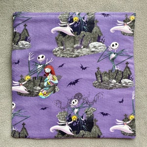 May include: Purple fabric with a repeating pattern of Jack Skellington and Sally from The Nightmare Before Christmas. The characters are depicted in a graveyard setting with bats and tombstones.
