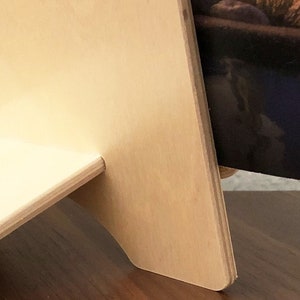 Może przedstawiać: Drewniany stojak na czasopisma w jasnym kolorze z czasopismem opierającym się o niego. Czasopismo zawiera zdjęcie basenu i tekst "2018 - 2019" na grzbiecie.