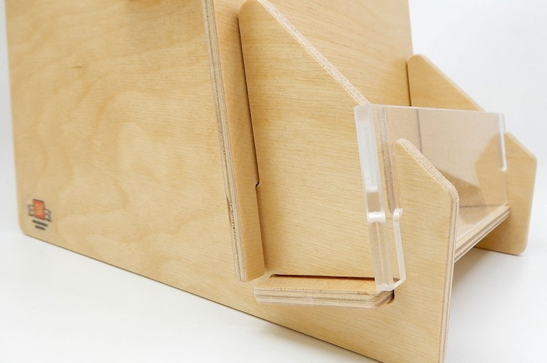 A wooden countertop display stand with a clear acrylic front. The stand has a simple design and is made of natural hue birch wood.