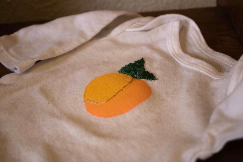 Newborn white onesie hand painted and embroidered peach