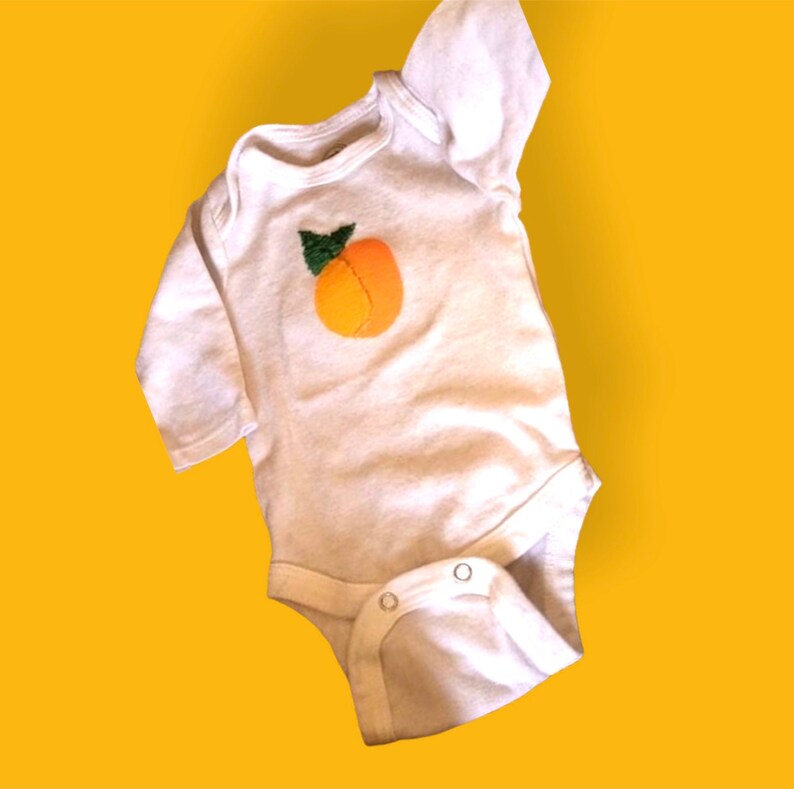 Newborn white onesie hand painted and embroidered peach