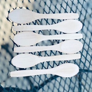 May include: Six wooden spoons stacked on top of each other. The spoons are all natural wood color and have a rounded bowl shape.