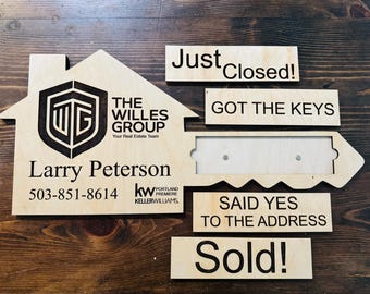 May include: A wooden house-shaped sign with a keyhole and a key. The sign says "Just Closed!" "Got the Keys" "Said Yes to the Address" and "Sold!" The sign also has the text "The Willes Group" "Your Real Estate Team" "Larry Peterson" "503-851-8614" "kw PORTLAND PREMIERE KELLERWILLIAMS".