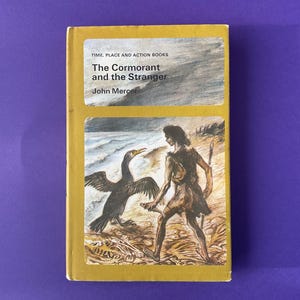 May include: A vintage book titled "The Cormorant and the Stranger" by John Mercer. The cover features an illustration of a cormorant bird and a person on a beach. The book has a yellow cover with text at the top and a purple background.