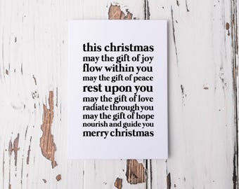 Könnte beinhalten: Eine weiße Weihnachtskarte mit schwarzem Text auf einem Hintergrund aus abgenutztem weißem Holz. Die Karte enthält eine Weihnachtsbotschaft: "this christmas may the gift of joy flow within you...merry christmas."