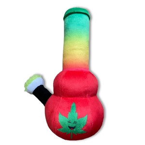 May include: A plush red and green bong with a smiling green marijuana leaf on the front. The bong has a rainbow colored neck.