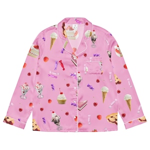 May include: A pink long-sleeved button-up shirt with a pattern of various desserts, including ice cream, cake, pie, and candy.