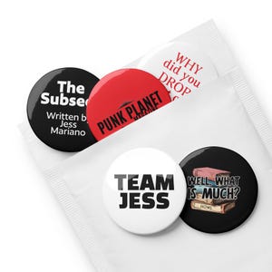 May include: A set of five round buttons with text and graphics. The buttons are black, red, and white. Text includes "The Subse", "PUNK PLANET MAGAZINE", "WHY did you DROP", "TEAM JESS", and "WELL, WHAT IS MUCH? HOWL". The buttons are in a white packet.