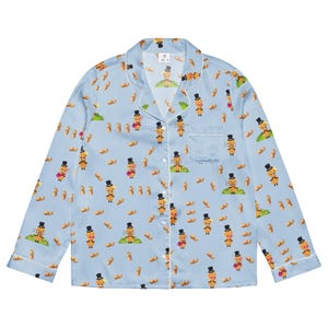 Può includere: Camicia da pigiama azzurra con un motivo ripetuto di arachidi dei cartoni animati con cappelli a cilindro e papillon. Il pigiama ha finiture bianche sul colletto, sui polsini e sulla tasca. Il tessuto è morbido e setoso.