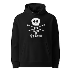 Könnte beinhalten: Schwarzer Kapuzenpullover mit einem weißen Totenkopf und gekreuzten Stricknadeln. Der Text "Knit or Go Home" befindet sich unter dem Totenkopf. Der Pullover hat eine Vordertasche und eine Kapuze mit Kordelzug.