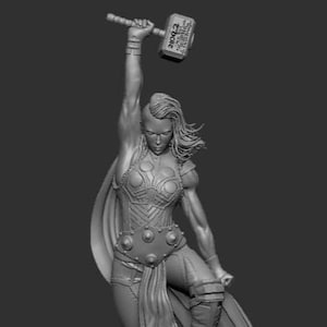 May include: A grey, detailed sculpture of a female figure holding a hammer. The figure is wearing a cape and armour, and is standing on a rocky base. The hammer has the words "Mjolnir" and "Asgardian" inscribed on it.
