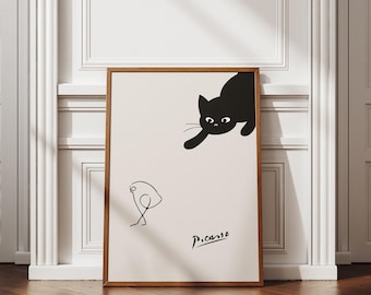 May include: Black and white minimalist art print featuring a black cat looking down at a simple line drawing of a bird. The print is signed "Picasso" in the bottom right corner.