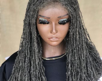 Può includere: Una parrucca lunga con dreadlock grigi e un fronte in pizzo. La parrucca è acconciata con dreadlock sciolte e fluenti.