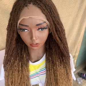 May include: A long, brown and blonde ombre synthetic dreadlock wig with a lace front.