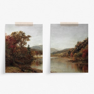 May include: Two paintings of a river scene with fall foliage. The left painting shows a river with a large tree on the bank. The right painting shows a river with a mountain range in the background.