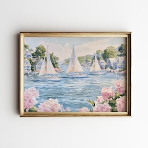 May include: A framed landscape painting depicting three sailboats on a blue harbor with coastal houses in the background. The foreground features clusters of light pink hydrangea flowers, and the entire scene is enclosed in a gold frame.