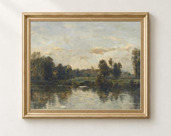 May include: A landscape painting in a gold frame depicting a calm river reflecting a line of dark green trees under a cloudy, pale blue and beige sky. The artwork features soft brushstrokes and muted earth tones throughout the scene.