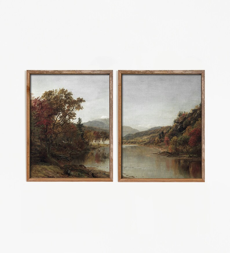 May include: Two framed landscape paintings depicting a river scene with trees and mountains in the background. The paintings are in a rustic wooden frame.